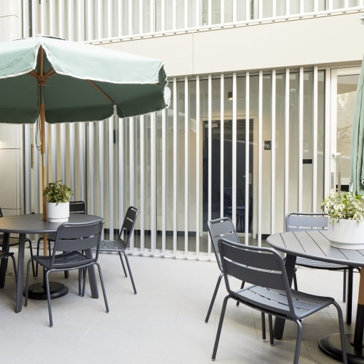 a patio with a table and chairs under an umbrella