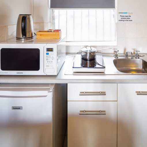 a kitchen with a microwave and sink and a sink and refrigerator