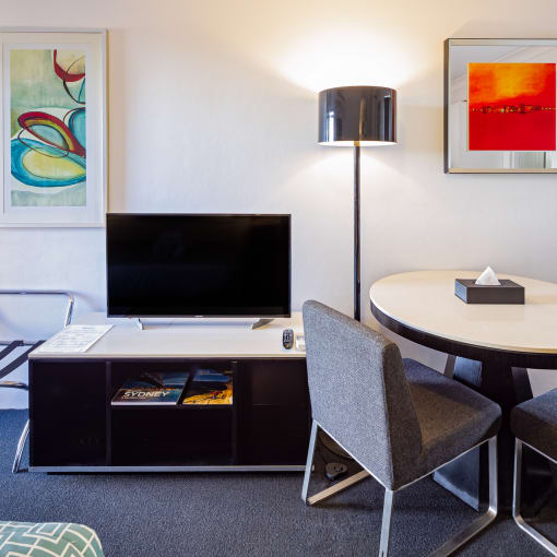 a living room with a tv and a table and chairs