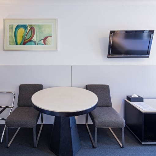 a room with a table and chairs and a television