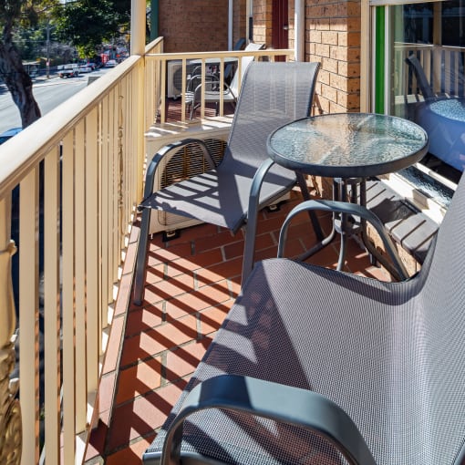 a patio with chairs and a table on a balcony