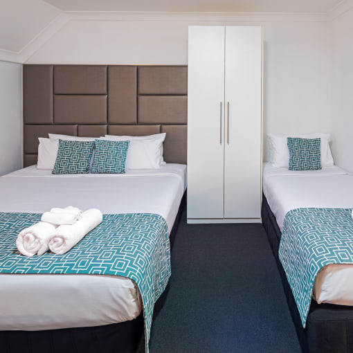 two beds in a hotel room with towels on them