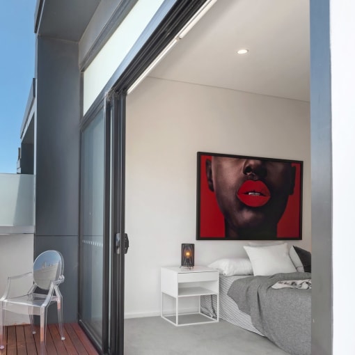 a small bedroom with a balcony and a door to a balcony