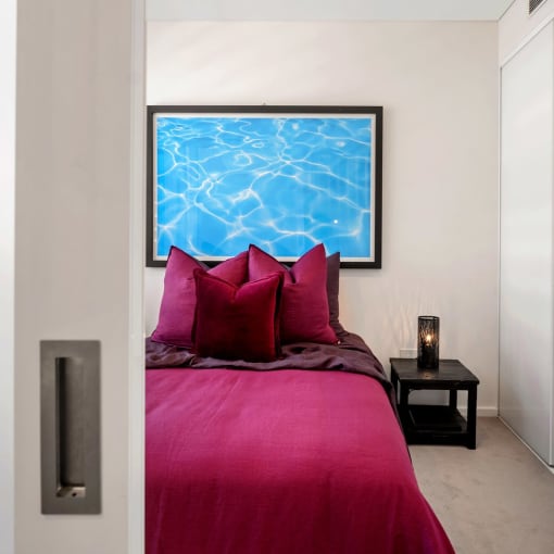 a bedroom with a bed and a picture of a pool