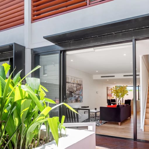 a living room with a staircase and a sliding glass door