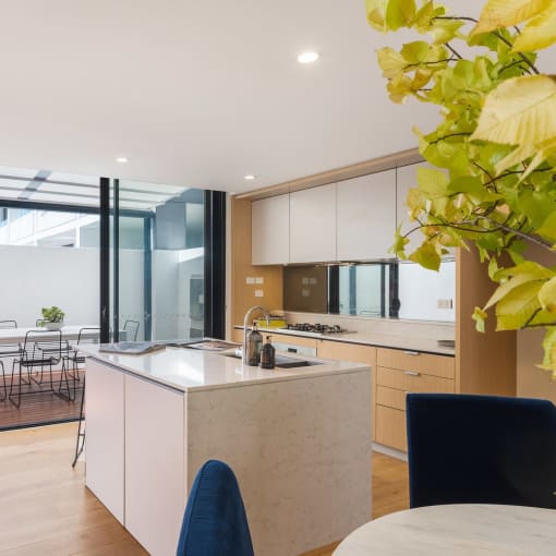 a kitchen with an island and a dining room with a table and chairs