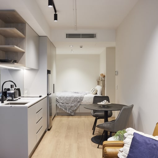 a small apartment with a kitchen and a bed