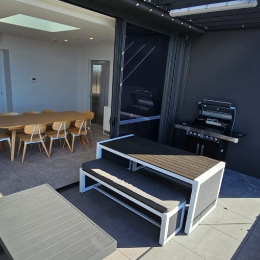 a patio with a table and chairs and a piano