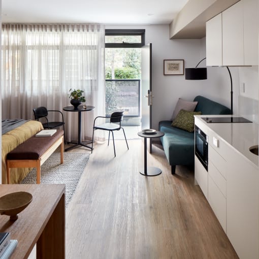 a studio apartment with a kitchen and living room