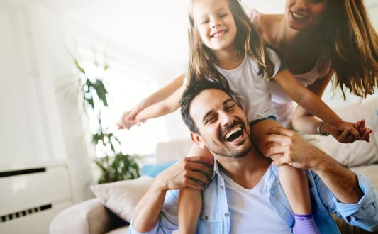 a man and woman sitting on a couch with a little girl
