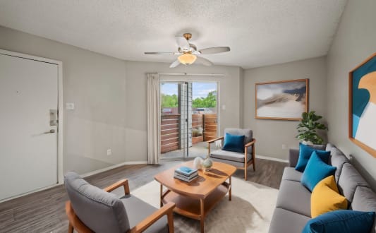 a living room with a couch and a table and a ceiling fan
