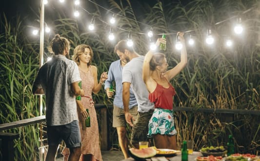 a group of people standing around a table with party lights