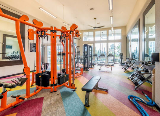 a gym with cardio machines and other equipment in the lobby of a building at Linden on the GreeneWay, Orlando