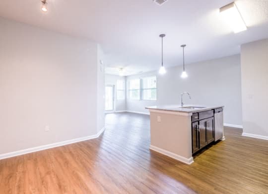 an empty living room and kitchen with a counter top in the middle at Linden on the GreeneWay, Orlando