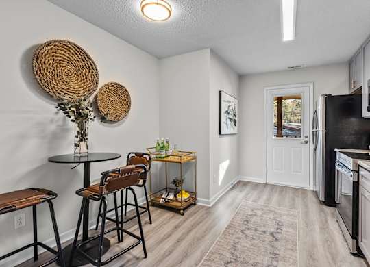 A kitchen with a black fridge and white walls at West Oak Apartments, Wake Forest