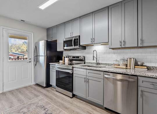 A kitchen with a refrigerator, oven, and microwave at West Oak Apartments, North Carolina 27587