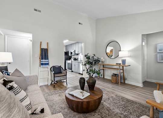 A living room with a grey couch and a wooden coffee table at West Oak Apartments, North Carolina 27587
