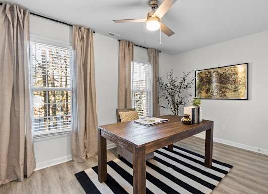 A room with a brown table and a striped rug at West Oak Apartments, Wake Forest, NC
