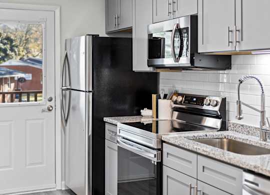 A kitchen with a black fridge and stove at West Oak Apartments, Wake Forest, NC