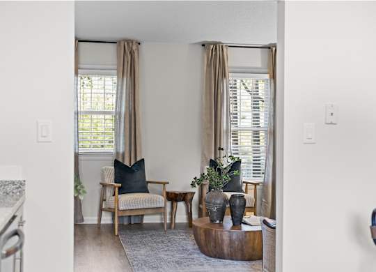 A living room with a chair, a table, and a plant at West Oak Apartments, Wake Forest, NC 27587