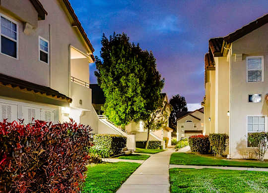 A residential street with houses and a sidewalk. at Legends at Rancho Belago, Moreno Valley, California