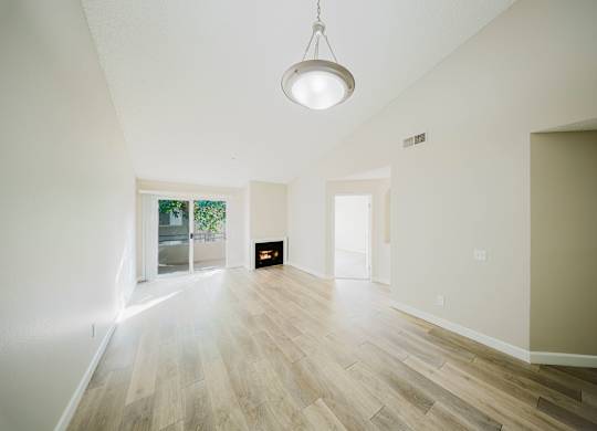 A room with a light hanging from the ceiling and a fireplace in the middle. at Legends at Rancho Belago, Moreno Valley