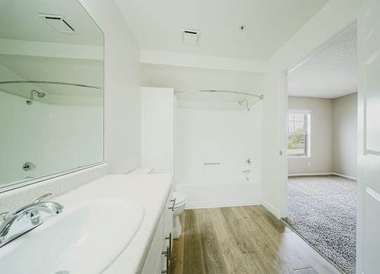 A white bathroom with a tub and a toilet. at Legends at Rancho Belago, Moreno Valley, CA