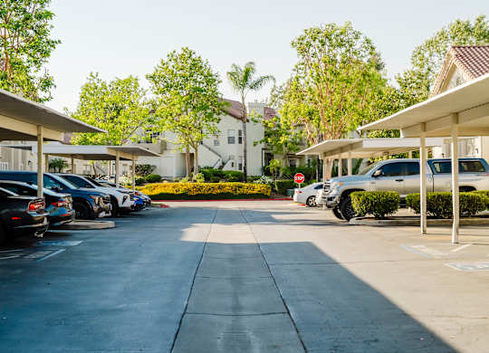 A parking lot with cars parked under a shelter. at Legends at Rancho Belago, Moreno Valley