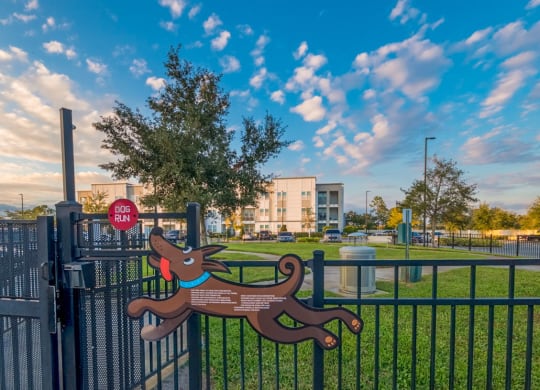 a park with a bench and a fence with a building in the background at Linden on the GreeneWay, Florida