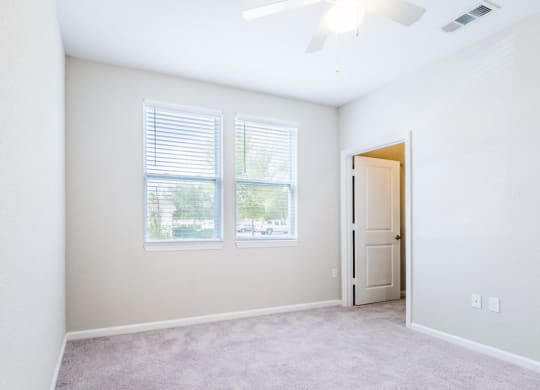 an empty living room with two windows and a door at Linden on the GreeneWay, Florida