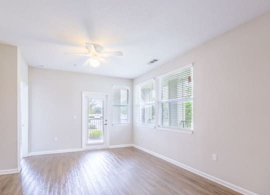 an empty living room with windows and a ceiling fan at Linden on the GreeneWay, Florida, 32824