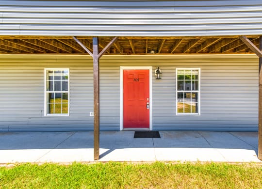 a red door on a white house with a porch at Ashford Place Apartments, North Carolina, 28081