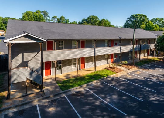 a building with red doors and a parking lot at Ashford Place Apartments, Kannapolis, NC 28081 