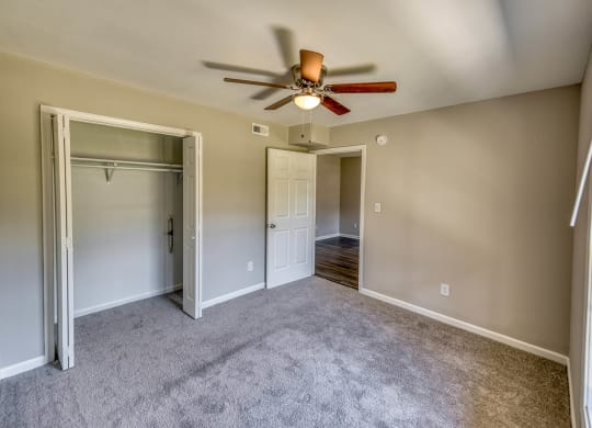 an empty living room with a ceiling fan and a closet at Ashford Place Apartments, Kannapolis, NC 28081
