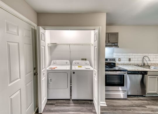 an empty laundry room with a washer and dryer in it at Ashford Place Apartments, Kannapolis, NC 
