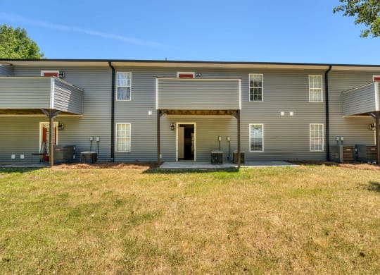 a large gray house with a yard in front of it at Ashford Place Apartments, Kannapolis North Carolina