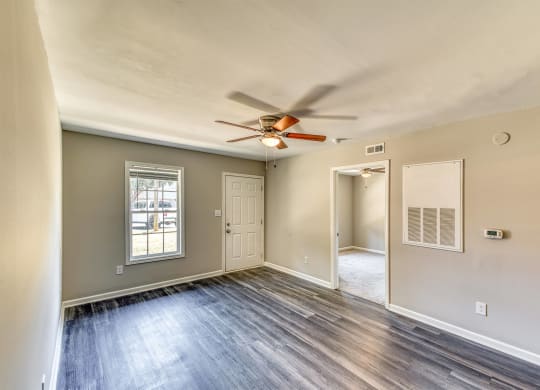 the living room of an empty home with a ceiling fan at Ashford Place Apartments, Kannapolis 