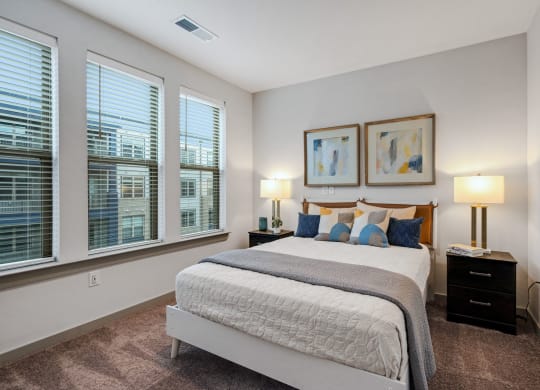 a bedroom with a large bed and three windows at Preston Ridge, Cary, 27513