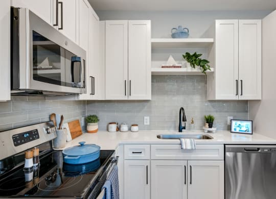 a kitchen with white cabinets and appliances and a sink at Preston Ridge, Cary