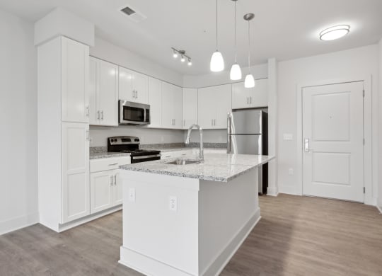 a kitchen with white cabinets and a large island with a sink at South Lake, Bowie, Maryland