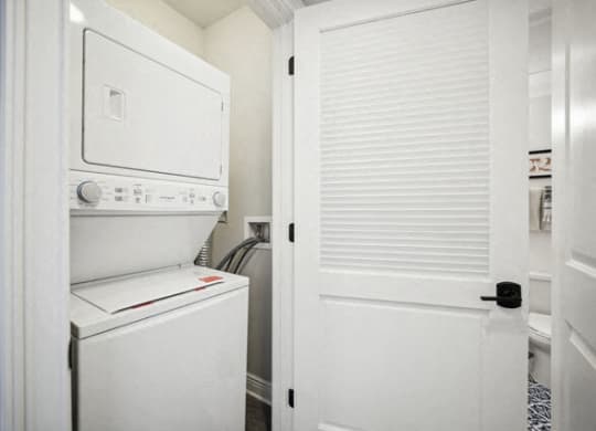 a laundry room with a washer and dryer and a white door at Park Kennedy, Washington
