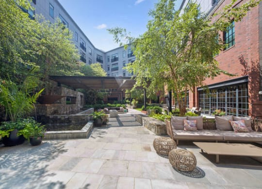 a courtyard with benches and trees and a building at Park Kennedy, Washington, DC, 20003