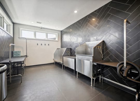 a kitchen with three stainless steel refrigerators and a table at Park Kennedy, Washington, DC