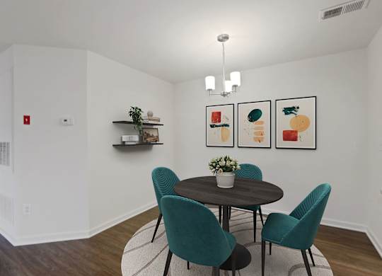 a dining room with a round table and four green chairs