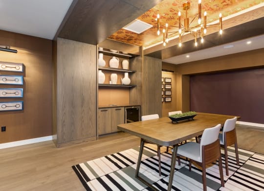 a dining room with a wooden dining table and white chairs on top of a black and white at Vyne One Loudoun, Virginia