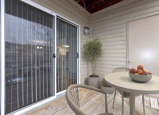 a patio with a table and chairs and a bowl of fruit