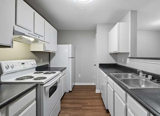A kitchen with white appliances and cabinets. at Greens at Stonecreek, Georgia