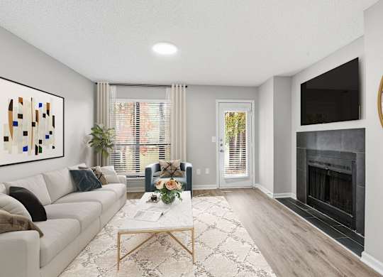 A modern living room with a fireplace and a large painting on the wall at Brampton Moors, Cary, NC, 27513