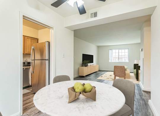 A kitchen with a refrigerator and a dining table with chairs at The Fields of Silver Spring, Silver Spring