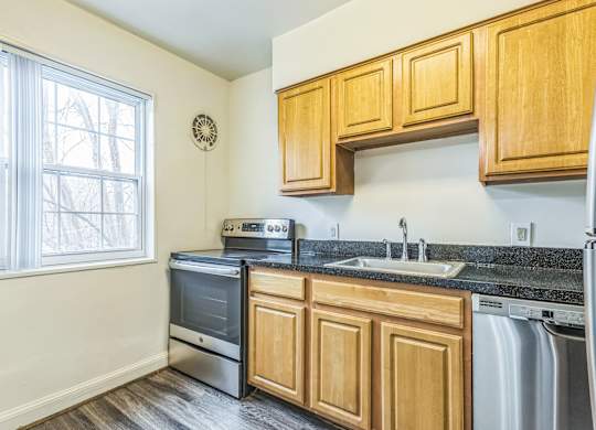 A kitchen with wooden cabinets and a black granite countertop.